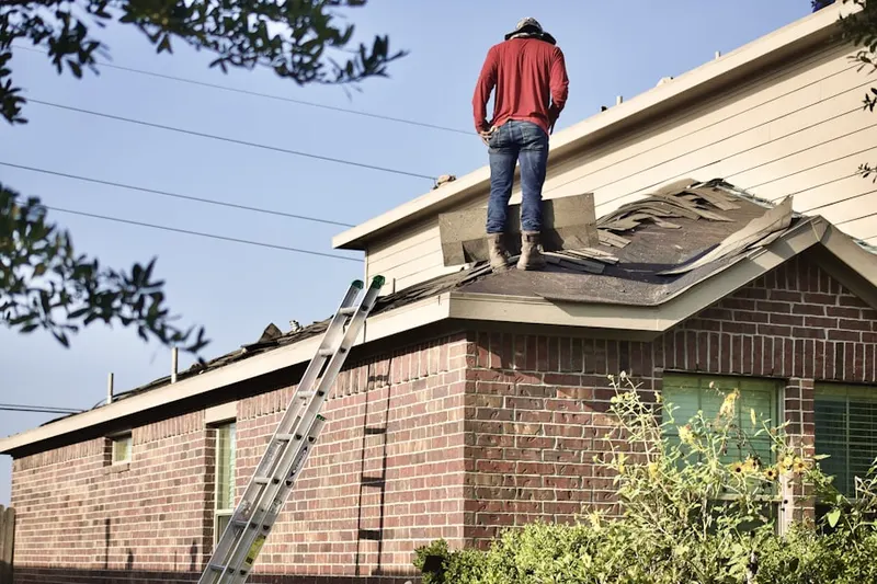Professional roofer working on a residential roof in Munns